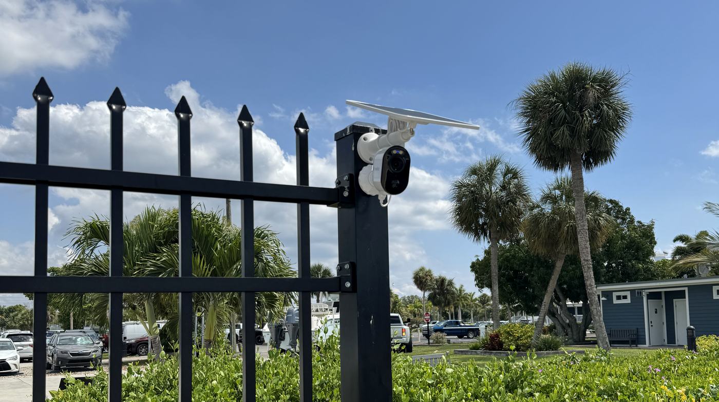 Solar-powered wireless security camera mounted on a gate post at a marina, installed by Allied Technologies