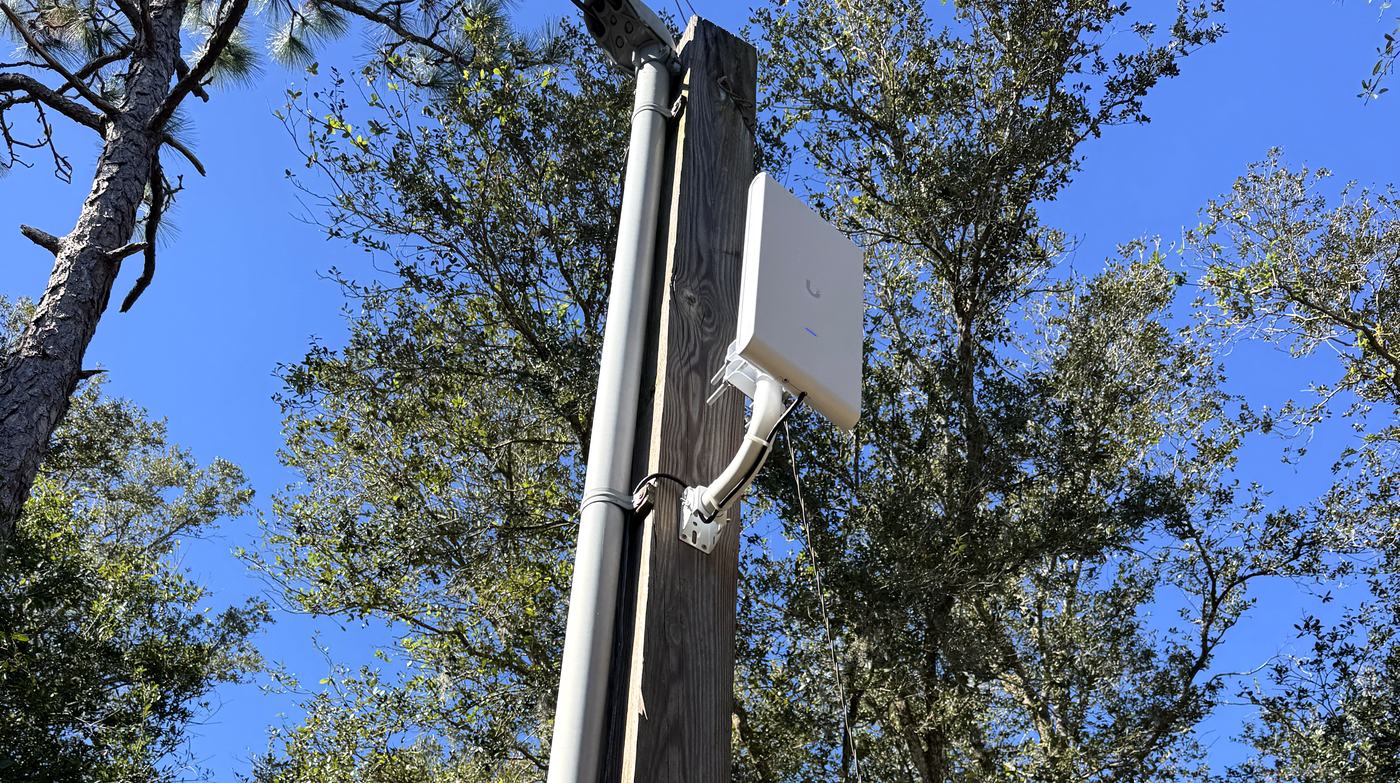 Outdoor business WiFi access point mounted on a pole with conduit, installed by Allied Technologies